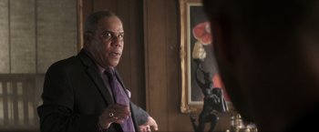 Movie still from “Parker” (2013), directed by Taylor Hackford – A man standing in front of a mirror in a room; Close Up shot, Over the shoulder angle