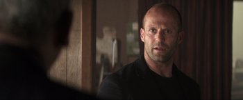 Movie still from “Parker” (2013), directed by Taylor Hackford – A man with a shaved head is looking into a mirror; Close Up shot, Over the shoulder angle