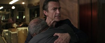 Movie still from “Parker” (2013), directed by Taylor Hackford – A man hugging another man with his arm around another man; Close Up shot, Over the shoulder angle