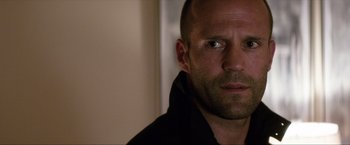 Movie still from “Parker” (2013), directed by Taylor Hackford – A man's face in a black shirt; Close Up shot, Over the shoulder angle