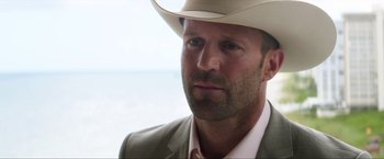 Movie still from “Parker” (2013), directed by Taylor Hackford – A person wearing a cowboy hat; Close Up shot, Over the shoulder angle