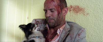 Movie still from “Parker” (2013), directed by Taylor Hackford – A man holding a cat with blood on his face; Close Up shot, Over the shoulder angle