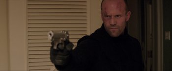 Movie still from “Parker” (2013), directed by Taylor Hackford – A man with a gun in his hand; Close Up shot, Low angle