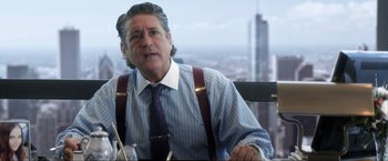 Movie still from “Parker” (2013), directed by Taylor Hackford – An older man sitting at a table in front of a city skyline; Close Up shot, Over the shoulder angle