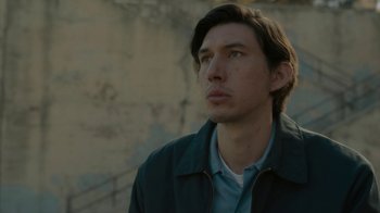Movie still from “Paterson” (2016), directed by Jim Jarmusch – A young man looking to his left while wearing a jacket; Close Up shot, Low angle
