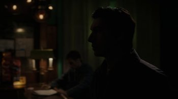 Movie still from “Paterson” (2016), directed by Jim Jarmusch – A man sitting at a table in a dark room; Close Up shot, Over the shoulder angle