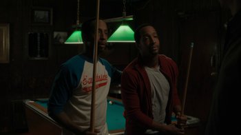 Movie still from “Paterson” (2016), directed by Jim Jarmusch – Two men are playing a game of billiards together; Medium shot, Over the shoulder angle