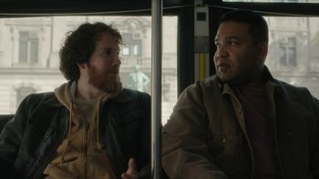 Movie still from “Paterson” (2016), directed by Jim Jarmusch – Two men are sitting on a bus together; Medium shot, Over the shoulder angle