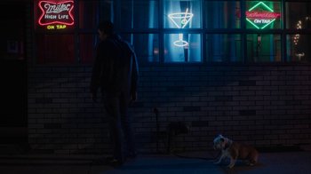 Movie still from “Paterson” (2016), directed by Jim Jarmusch – A man and a dog in front of a brick wall; Wide shot, Low angle