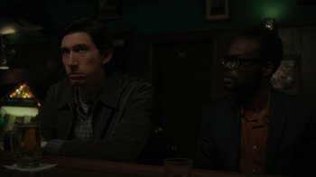 Movie still from “Paterson” (2016), directed by Jim Jarmusch – Two men sitting at a table in a dark room; Medium shot, Over the shoulder angle