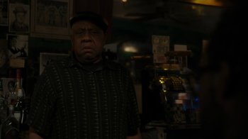 Movie still from “Paterson” (2016), directed by Jim Jarmusch – An older man wearing a hat and a striped shirt; Medium shot, Over the shoulder angle