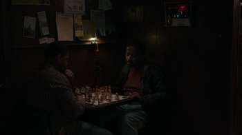 Movie still from “Paterson” (2016), directed by Jim Jarmusch – Two men sitting at a table playing a game of chess; Medium shot, High angle