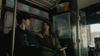 Movie still from “Paterson” (2016), directed by Jim Jarmusch – Two people are sitting on a public transit bus; Medium shot, Over the shoulder angle