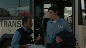 Movie still from “Paterson” (2016), directed by Jim Jarmusch – Two men standing next to each other in front of a bus; Medium shot, Over the shoulder angle