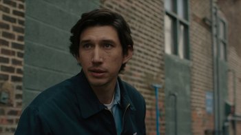 Movie still from “Paterson” (2016), directed by Jim Jarmusch – A person wearing a jacket near a brick wall; Close Up shot, Over the shoulder angle