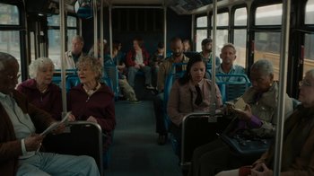 Movie still from “Paterson” (2016), directed by Jim Jarmusch – A group of people sitting on a bus; Wide shot, High angle