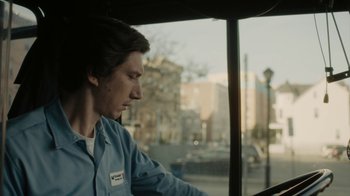 Movie still from “Paterson” (2016), directed by Jim Jarmusch – A man sitting in a bus looking out the window; Close Up shot, Low angle