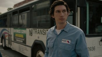 Movie still from “Paterson” (2016), directed by Jim Jarmusch – A man standing in front of a transit bus; Close Up shot, Low angle