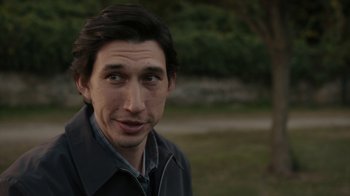 Movie still from “Paterson” (2016), directed by Jim Jarmusch – A person wearing a jacket near a tree; Close Up shot, Over the shoulder angle