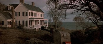Movie still from “Patriot Games” (1992), directed by Phillip Noyce – A white house sitting on top of a lush green hillside; Extreme Wide shot, Low angle