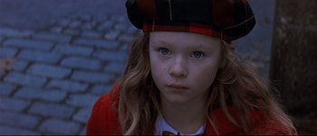 Movie still from “Patriot Games” (1992), directed by Phillip Noyce – A little girl wearing a red jacket and a plaid hat; Close Up shot, High angle