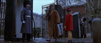 Movie still from “Patriot Games” (1992), directed by Phillip Noyce – A woman talking on a cell phone next to a woman in a red coat; Wide shot, Low angle