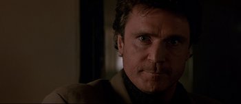 Movie still from “Patriot Games” (1992), directed by Phillip Noyce – A man's face in a dark room; Close Up shot, Low angle