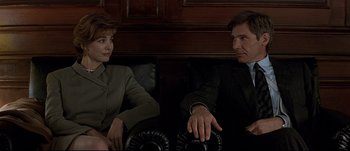 Movie still from “Patriot Games” (1992), directed by Phillip Noyce – A man and a woman sitting next to each other on a couch; Medium shot, Low angle