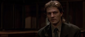 Movie still from “Patriot Games” (1992), directed by Phillip Noyce – A person wearing a suit and tie; Close Up shot, Low angle