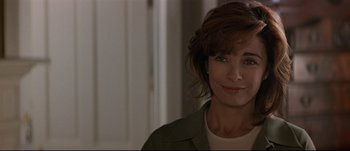 Movie still from “Patriot Games” (1992), directed by Phillip Noyce – A person smiling for the camera; Close Up shot, Over the shoulder angle