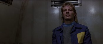 Movie still from “Patriot Games” (1992), directed by Phillip Noyce – A man with long blonde hair wearing a blue jacket; Close Up shot, Low angle