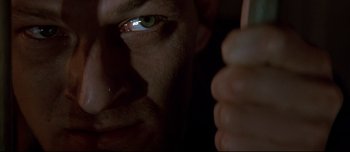 Movie still from “Patriot Games” (1992), directed by Phillip Noyce – A man's face with a finger up to his eye; Extreme Close Up shot, Low angle