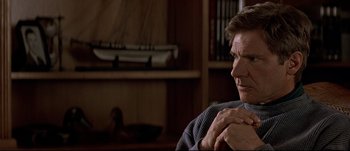Movie still from “Patriot Games” (1992), directed by Phillip Noyce – An older man sitting in a chair in a living room; Close Up shot, Over the shoulder angle