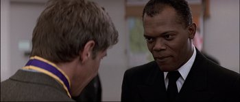 Movie still from “Patriot Games” (1992), directed by Phillip Noyce – A man in a suit and tie talking to another man in a suit and tie; Close Up shot, Over the shoulder angle