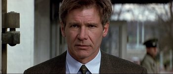 Movie still from “Patriot Games” (1992), directed by Phillip Noyce – A person wearing a suit and tie; Close Up shot, Low angle