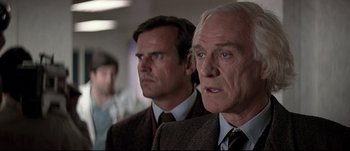 Movie still from “Patriot Games” (1992), directed by Phillip Noyce – Two men in suits and ties are looking at something; Close Up shot, Low angle