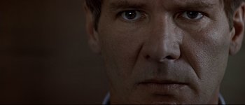 Movie still from “Patriot Games” (1992), directed by Phillip Noyce – A man's face with a dark background; Extreme Close Up shot, Low angle