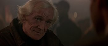 Movie still from “Patriot Games” (1992), directed by Phillip Noyce – An older man with white hair looking at the camera; Close Up shot, Over the shoulder angle