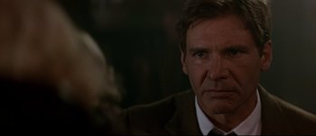 Movie still from “Patriot Games” (1992), directed by Phillip Noyce – A person wearing a suit and tie; Close Up shot, Over the shoulder angle