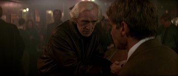 Movie still from “Patriot Games” (1992), directed by Phillip Noyce – A man in a leather jacket talking to another man in a brown jacket; Close Up shot, Over the shoulder angle