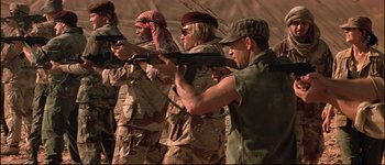 Movie still from “Patriot Games” (1992), directed by Phillip Noyce – A group of men holding guns in a field; Medium shot, Low angle