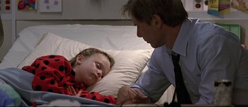 Movie still from “Patriot Games” (1992), directed by Phillip Noyce – A man and a little girl laying in a bed; Close Up shot, Over the shoulder angle