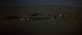 Movie still from “Patriot Games” (1992), directed by Phillip Noyce – A group of tents in the desert at night; Extreme Wide shot, High angle