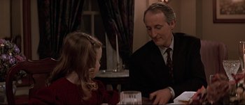 Movie still from “Patriot Games” (1992), directed by Phillip Noyce – A man and a little girl sitting at a dinner table; Close Up shot, Over the shoulder angle