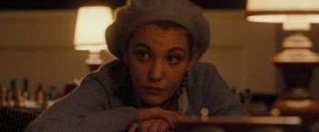 Movie still from “Pawn Sacrifice” (2014), directed by Edward Zwick – A young woman wearing a hat is leaning on a table; Close Up shot, Over the shoulder angle
