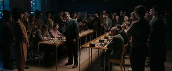 Movie still from “Pawn Sacrifice” (2014), directed by Edward Zwick – A group of people sitting at tables playing chess; Extreme Wide shot, High angle