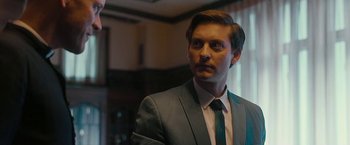 Movie still from “Pawn Sacrifice” (2014), directed by Edward Zwick – A man wearing a suit and tie in front of a window; Close Up shot, Over the shoulder angle