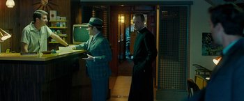 Movie still from “Pawn Sacrifice” (2014), directed by Edward Zwick – Two men standing in front of a television in a room; Medium shot, Over the shoulder angle