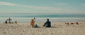 Movie still from “Pawn Sacrifice” (2014), directed by Edward Zwick – A man and a woman sitting on the beach looking at each other; Extreme Wide shot, High angle