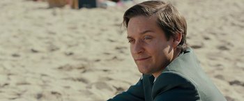Movie still from “Pawn Sacrifice” (2014), directed by Edward Zwick – A person sitting on the beach; Close Up shot, Over the shoulder angle